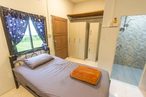 a bedroom with a bed with a shower and a tub at The Travelers Friend En Suite dorm room AC in Ban Ai Dao