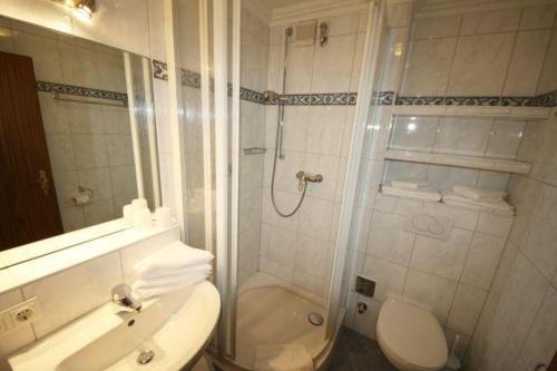 ein Bad mit einer Dusche, einem WC und einem Waschbecken in der Unterkunft Norderhoog Whg. 71 / 3.OG / W Wohnung 71 in Westerland