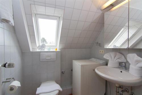 a bathroom with a sink and a toilet and a window at Haus-Seemoewe in Archsum