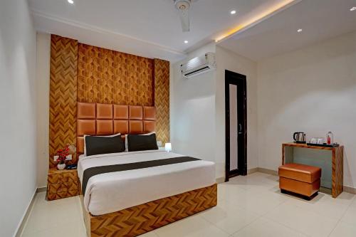 a bedroom with a large bed with a wooden headboard at Hotel O Skycity in Kānpur