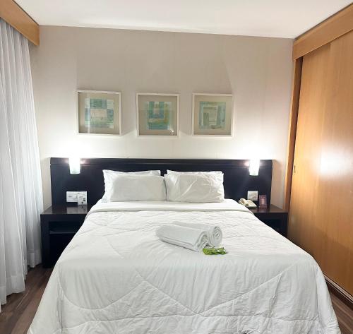 a bedroom with a white bed with two night stands at Mercure São Paulo vila Olimpia premium in Sao Paulo