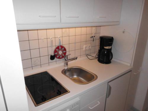 una piccola cucina con lavandino e bancone di Loreley-12 a Sankt Peter-Ording