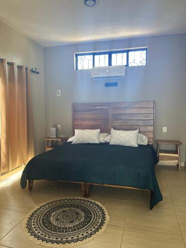 a bedroom with a large bed with a wooden headboard at Estudio a 5 minutos de Sayulita -Parota 1 in San Ignacio