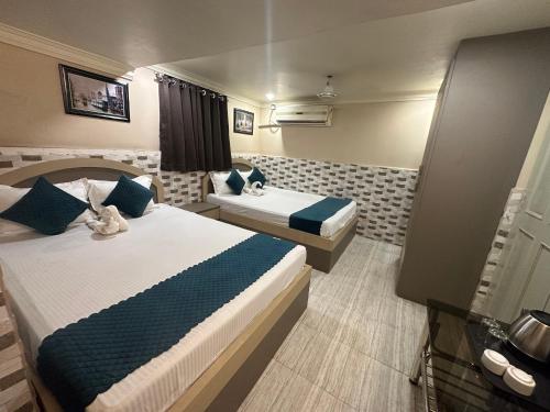 une chambre d'hôtel avec deux lits et un canapé dans l'établissement Hotel Vinayak, à Kharagpur