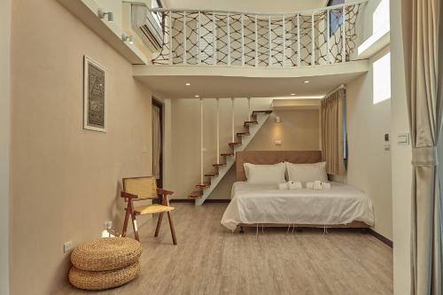 a bedroom with a bed and a staircase at Cliff Villa in Hengchun