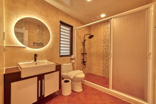 La salle de bains est pourvue de toilettes, d'un lavabo et d'une douche. dans l'établissement Cliff Villa, à Hengchun Old Town