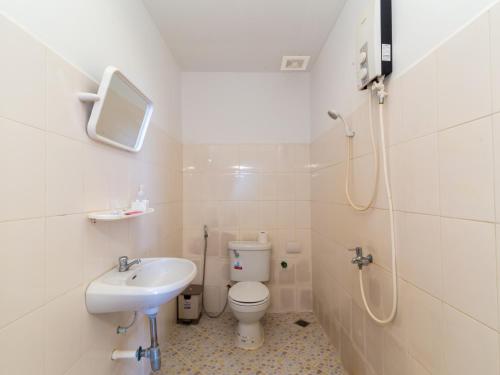 a white bathroom with a toilet and a sink at Blossoming Romduol Boutique in Siem Reap