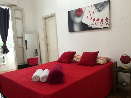 a bedroom with a red bed with towels on it at Aconchegante Lapa in Rio de Janeiro