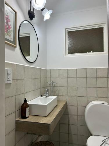 a bathroom with a sink and a mirror and a toilet at El Garaje in Puerto Deseado
