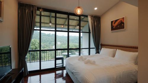 una camera con un letto e una grande finestra di Gustavia House and Mountain a Ban Nong Rang Chang