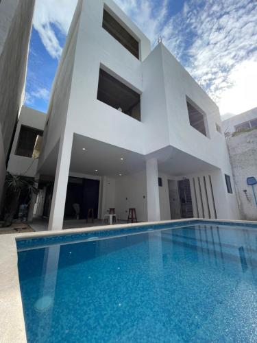a house with a swimming pool in front of it at Alce33 in Cancún