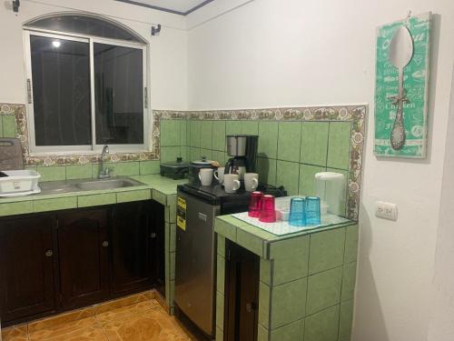 a kitchen with green tiled counters and a sink at SilvaMar in Puntarenas