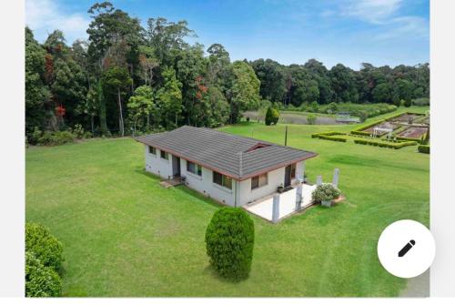 a small house on a large grass field at Central 3-Bedroom House with Garden in Mount Tamborine