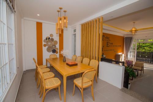 a dining room with a wooden table and chairs at Suri Homestay in Da Lat