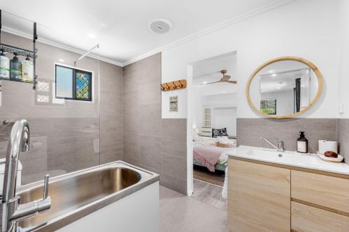 a bathroom with a sink and a mirror and a bed at Little Sunshine - Private acreage Guest Home in Hervey Bay