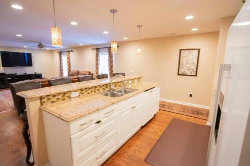 a kitchen with a sink and a living room at Charming Apartment on Oak in Cookeville