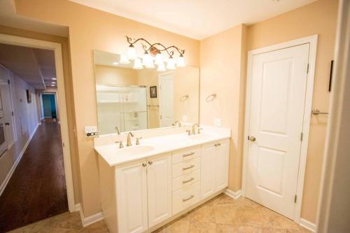 a bathroom with a white sink and a mirror at Charming Apartment on Oak in Cookeville