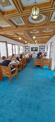 un groupe de personnes assises à des tables dans une pièce dans l'établissement Hotel Ansi Boutique W&S terrace, à Boukhara