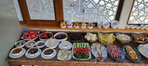 una tabella piena di diversi tipi di alimenti su piatti di Hotel Ansi Boutique W&S terrace a Bukhara
