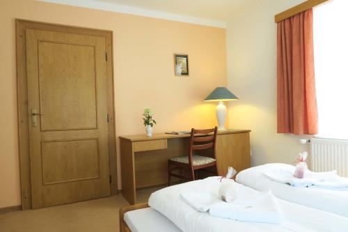 a hotel room with two beds and a desk and a chair at Horský pension Gendorf in Cerny Dul