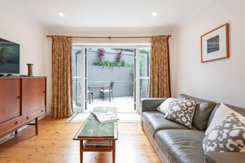 a living room with a couch and a table at Sydney -Cammeray apartment in Sydney