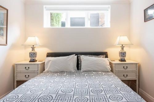 a bedroom with a bed and two night stands with lamps at Sydney -Cammeray apartment in Sydney