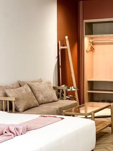 a living room with a couch and a table at SO Zen Hotel Silom Bangkok in Bang Rak