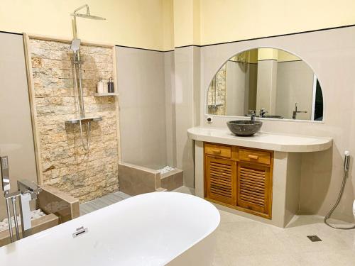 a bathroom with a tub and a sink and a shower at Ayodya Batur Villa in Kintamani