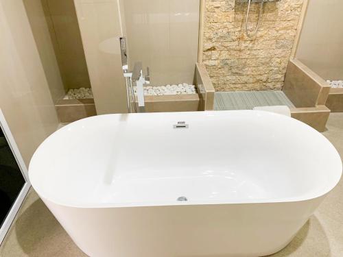 a white tub in a bathroom with a shower at Ayodya Batur Villa in Kintamani