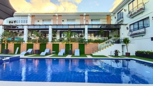 un hôtel avec une piscine en face d'un bâtiment dans l'établissement Casa La Silvinas Hotel & Event Resort, à Tagaytay