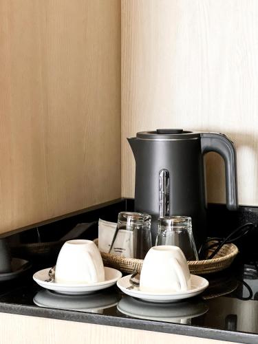 a counter with two plates and a coffee pot at SO Zen Hotel Silom Bangkok in Bang Rak