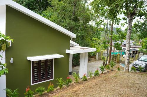 a green house with a window in a yard at B'camp Resorts & Homestays in Wayanad
