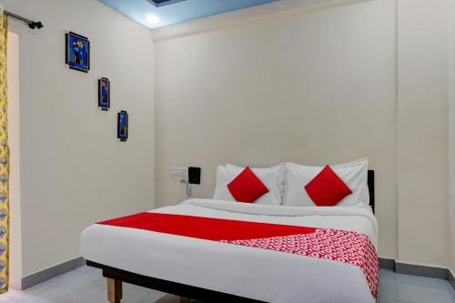 a bedroom with a bed with red and white pillows at Hotel Royal Inn in Pune