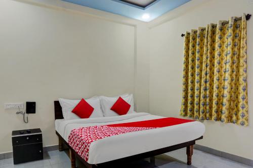 a bedroom with a bed with red pillows at Hotel Royal Inn in Pune