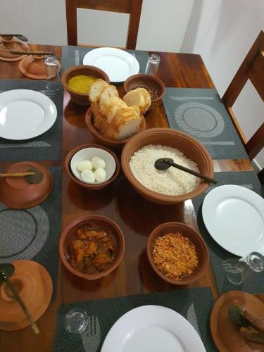 een tafel met borden en kommen met eten erop bij Blooming Holiday Resort in Anuradhapura