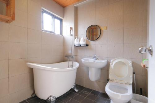 安平的住宿－RE+Wood民宿，带浴缸、卫生间和盥洗盆的浴室