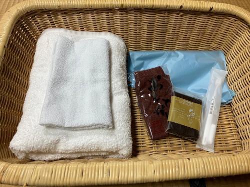 una cesta con toallas y una caja de jabón y chocolate en MONJUNO FUKUCHI en Kamikishida