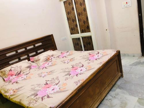 ein Schlafzimmer mit einem Bett mit einer Blumendecke darauf in der Unterkunft Dumzy's Tombs View in Hyderabad