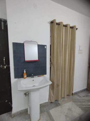La salle de bains est pourvue d'un lavabo, d'un miroir et d'une douche. dans l'établissement Dumzy's Tombs View, à Hyderabad