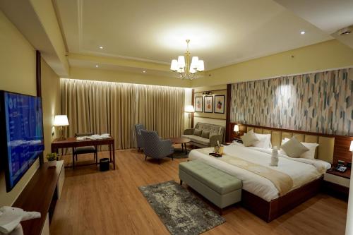 Habitación de hotel con cama grande y TV en M2 Square by Monday Premium, en Nagpur