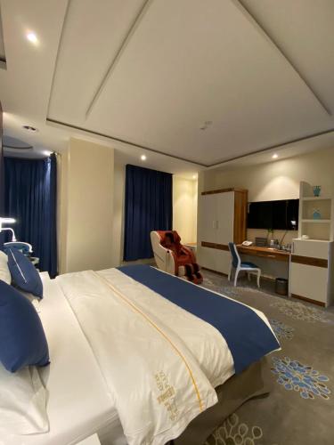 a bedroom with a large bed and a desk at فندق الفاو بلازا in Sharurah