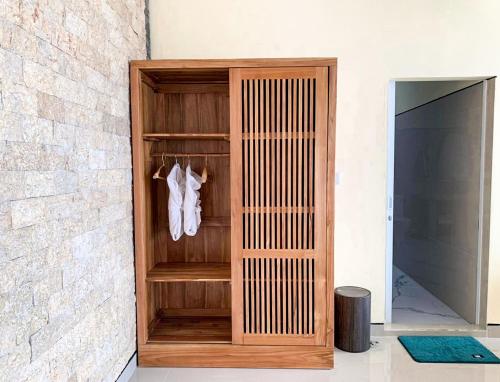 a wooden closet with white shoes hanging on a wall at Ayodya Batur Villa in Kintamani