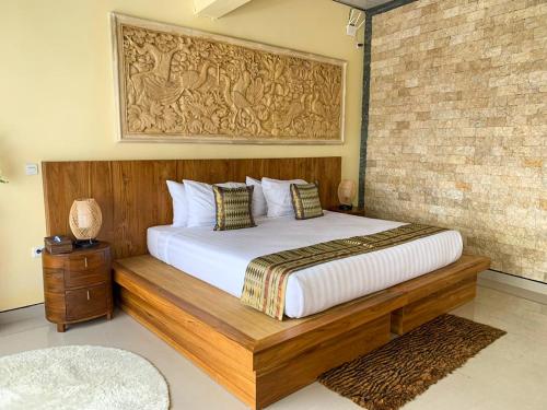 a bedroom with a large bed with a wooden frame at Ayodya Batur Villa in Kintamani