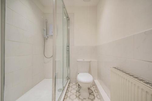 a white bathroom with a toilet and a shower at Private room. Fast Wi-Fi. Modern Fittings in Harwood