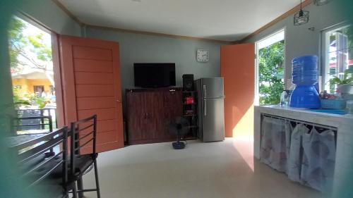 a kitchen with a red door and a television at BOHOL Simple and Elegant Furnished Studio in Tagbilaran City
