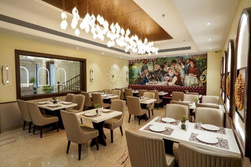 a restaurant with tables and chairs and a painting on the wall at M2 Square by Monday Premium in Nagpur