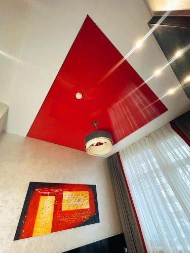 a red ceiling in a room with a window at Mildom Premium Hotel in Almaty