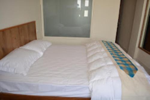 a large bed with white sheets and pillows at Aamantran@FortMaheshwar,Maheshwar in Maheshwar