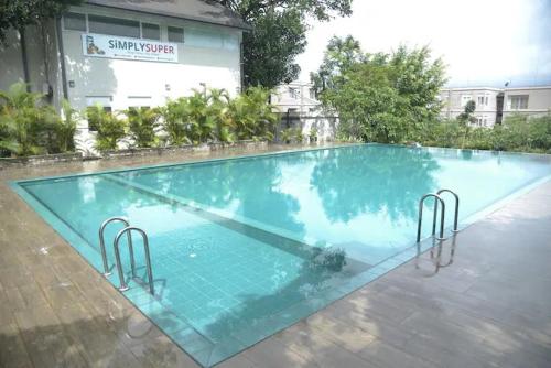 a large swimming pool with blue water in front of a building at Cozy 2 bed 1 bath Apartment for rent in Homagama