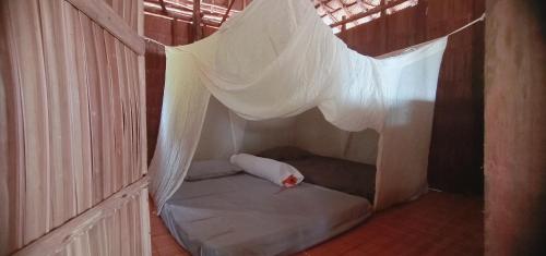 Cette petite chambre comprend un lit avec moustiquaire. dans l'établissement Manyaifun Homestay, à Waisai
